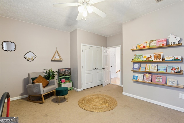 living area featuring carpet flooring, baseboards, and a textured ceiling