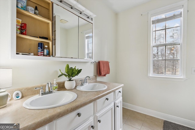 bathroom featuring tile patterned flooring, double vanity, baseboards, and a sink