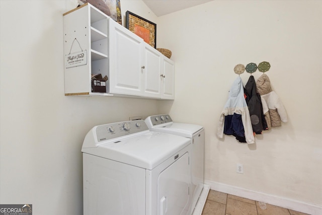 washroom with washing machine and clothes dryer, cabinet space, and baseboards