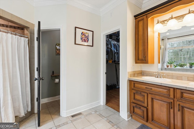 full bathroom with a walk in closet, crown molding, baseboards, tile patterned floors, and vanity