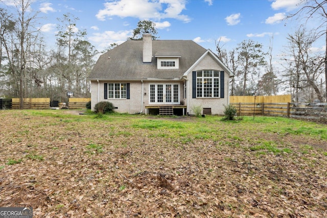 back of house featuring brick siding, crawl space, a chimney, and fence