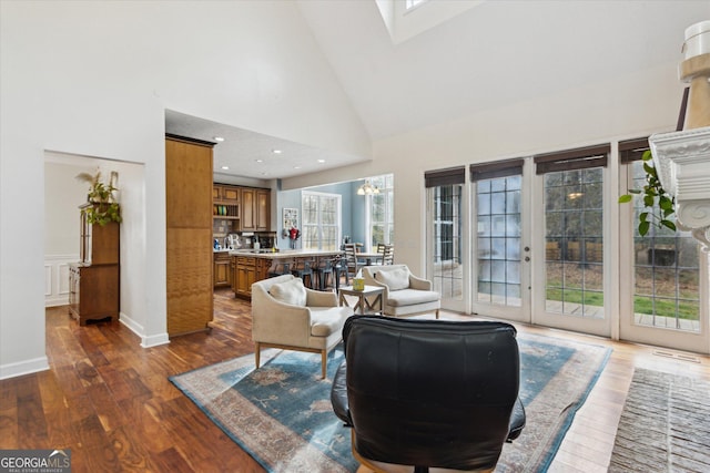 living room featuring a skylight, recessed lighting, high vaulted ceiling, and dark wood-type flooring