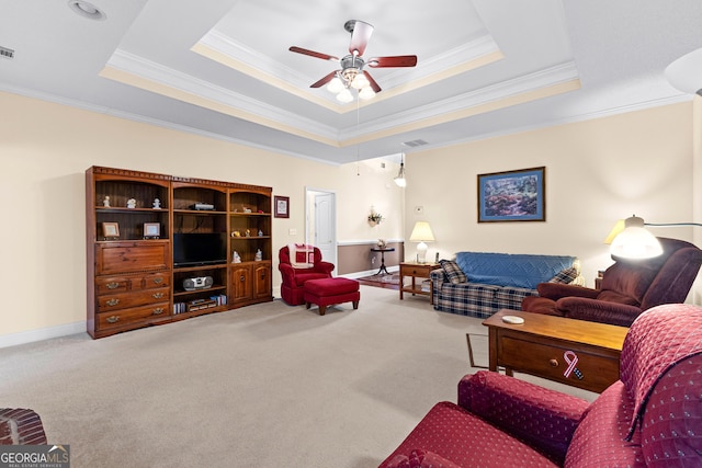 living area featuring carpet, a tray ceiling, and ornamental molding