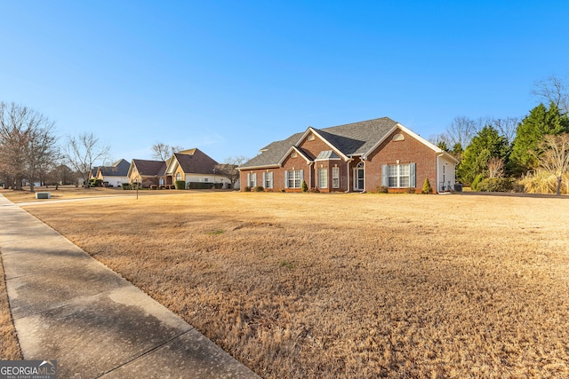 view of front of property featuring brick siding and a front yard