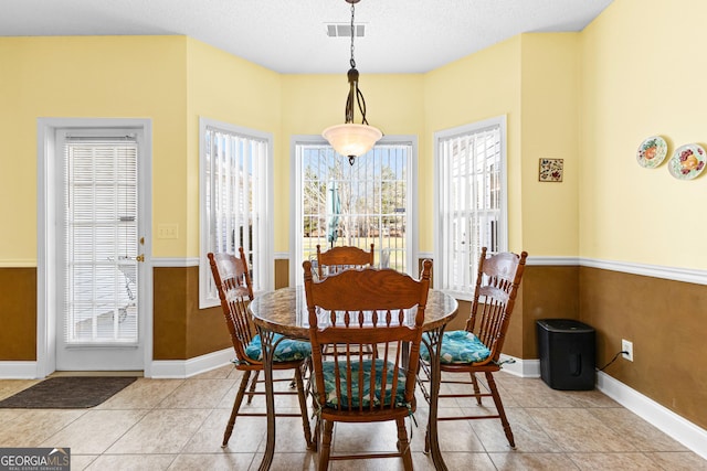 dining room with light tile patterned flooring, visible vents, and baseboards