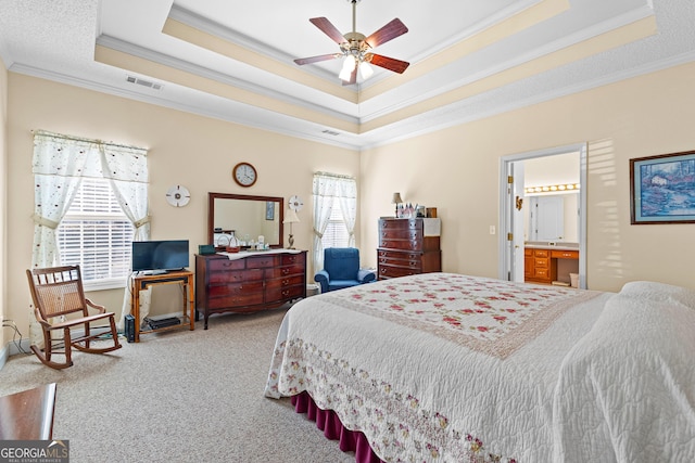 carpeted bedroom with multiple windows, a raised ceiling, visible vents, and crown molding