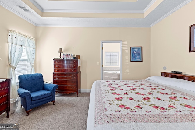 carpeted bedroom with a tray ceiling, visible vents, ensuite bath, and crown molding