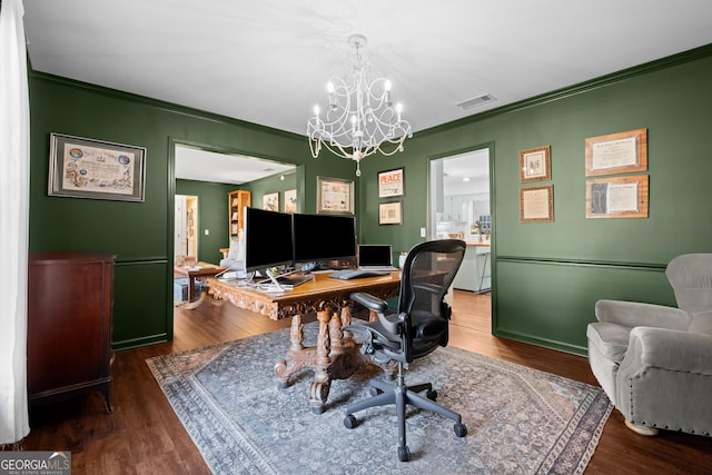 office space with visible vents, crown molding, and wood finished floors