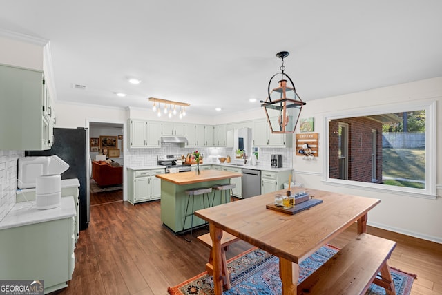 kitchen featuring backsplash, dark wood-type flooring, butcher block countertops, stainless steel appliances, and a sink