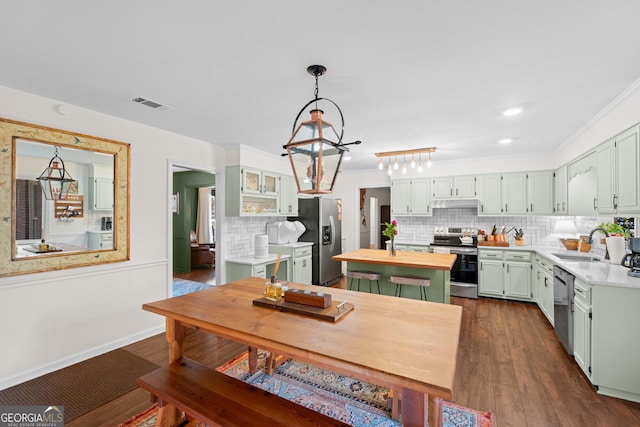 kitchen featuring backsplash, dark wood finished floors, stainless steel appliances, wood counters, and a sink