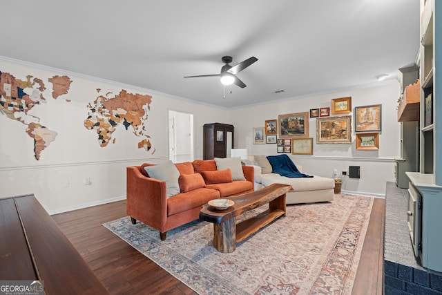 living room with dark wood finished floors, baseboards, a ceiling fan, and ornamental molding