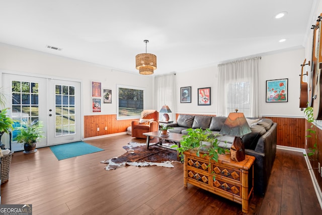 living area with visible vents, french doors, wood finished floors, and a wainscoted wall