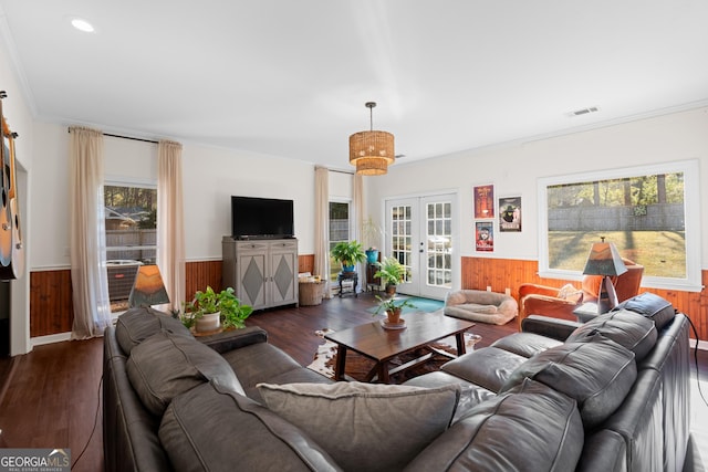 living area with a wainscoted wall, a healthy amount of sunlight, and french doors