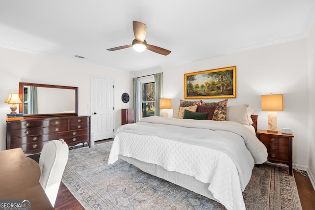 bedroom featuring wood finished floors, visible vents, and ornamental molding