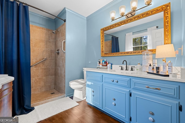 full bathroom featuring crown molding, toilet, a tile shower, wood finished floors, and vanity