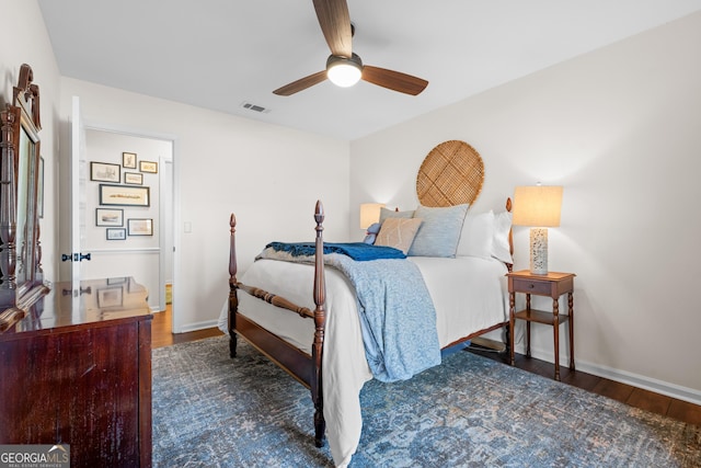 bedroom with ceiling fan, wood finished floors, visible vents, and baseboards