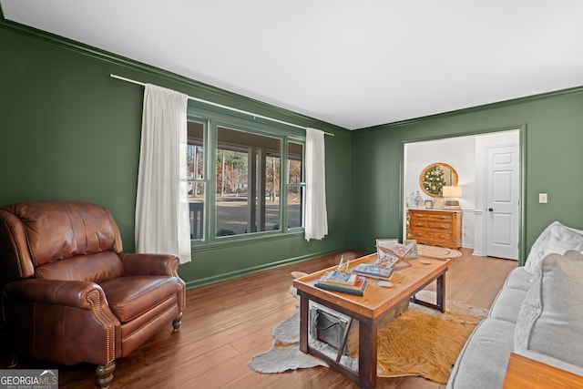 living area with baseboards and wood finished floors