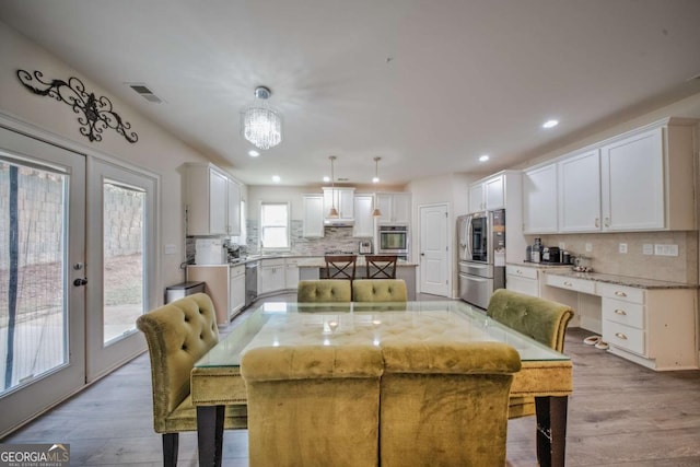 dining room with recessed lighting, visible vents, a notable chandelier, and wood finished floors