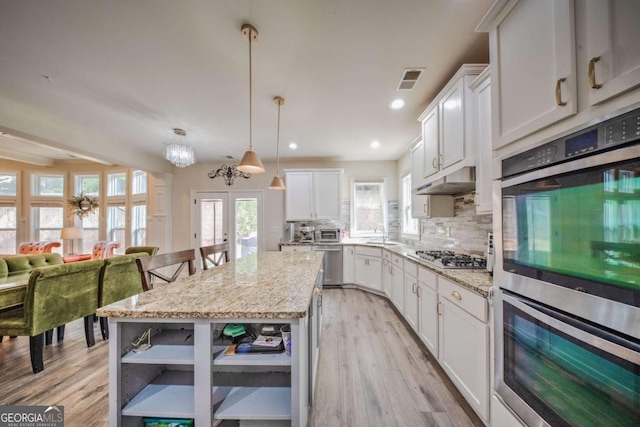 kitchen featuring tasteful backsplash, visible vents, stainless steel appliances, white cabinetry, and open shelves