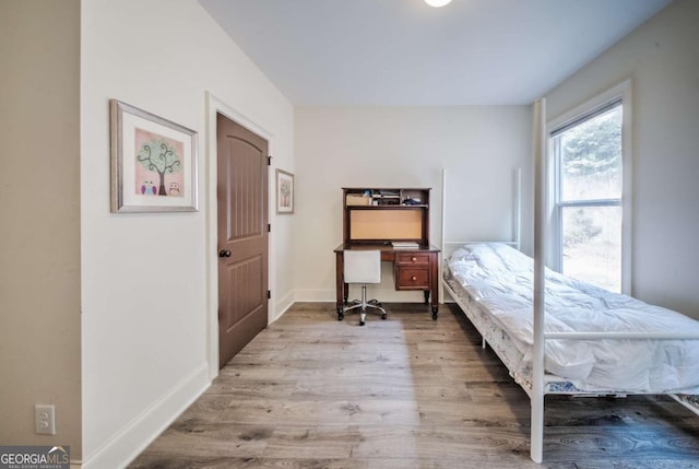 bedroom with wood finished floors and baseboards