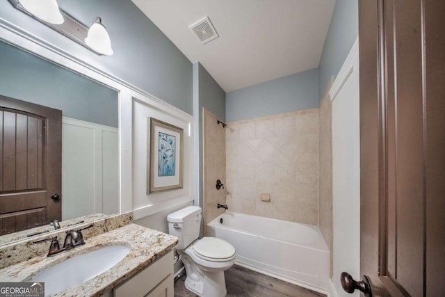 full bathroom featuring visible vents, toilet, wood finished floors, washtub / shower combination, and vanity