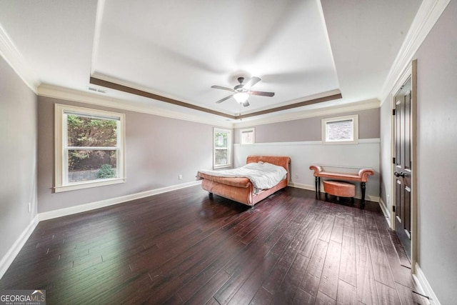 bedroom featuring visible vents, dark wood-type flooring, baseboards, a tray ceiling, and ornamental molding