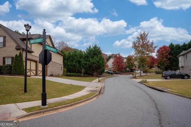 view of road with curbs, traffic signs, street lighting, and sidewalks