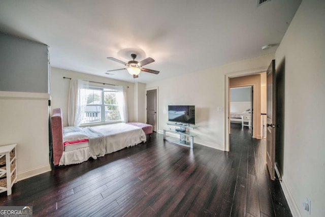 bedroom featuring baseboards, dark wood-style floors, and a ceiling fan