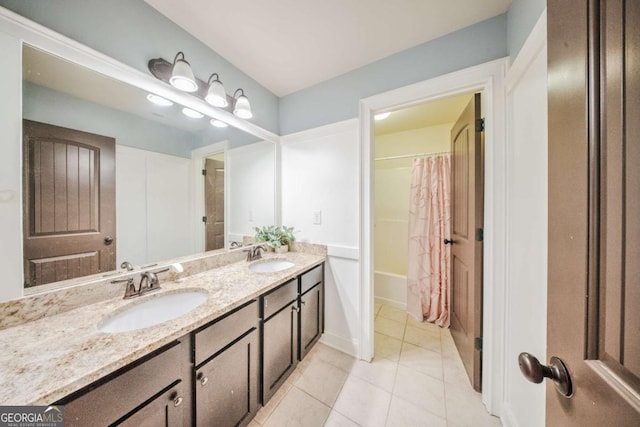 bathroom featuring tile patterned floors, double vanity, shower / bath combo, and a sink