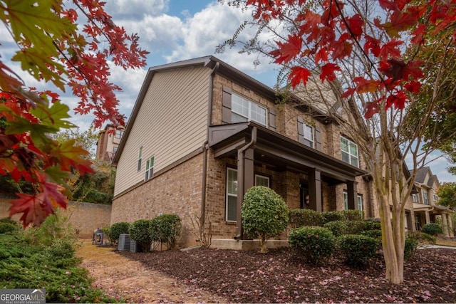 view of side of property with central AC unit and brick siding