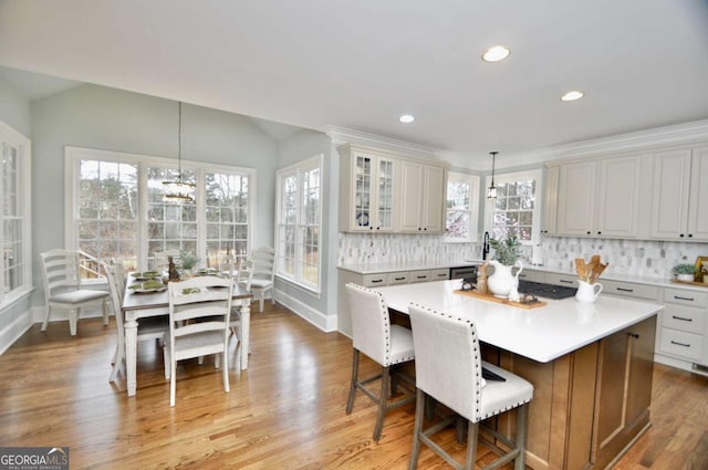 kitchen featuring decorative backsplash, a kitchen island, a chandelier, and light countertops