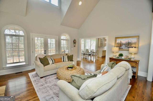 living room with visible vents, french doors, baseboards, and wood finished floors