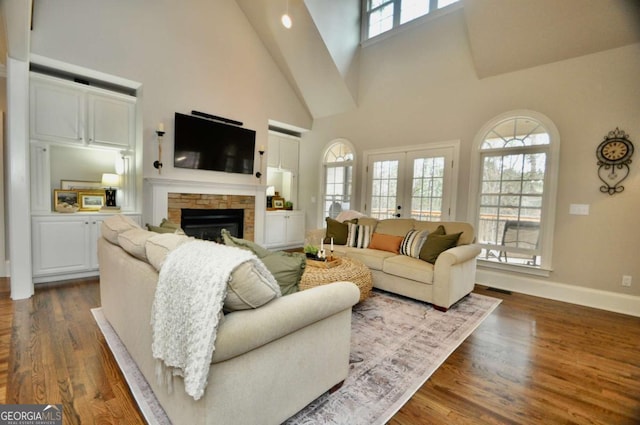 living area with dark wood finished floors, french doors, high vaulted ceiling, and baseboards