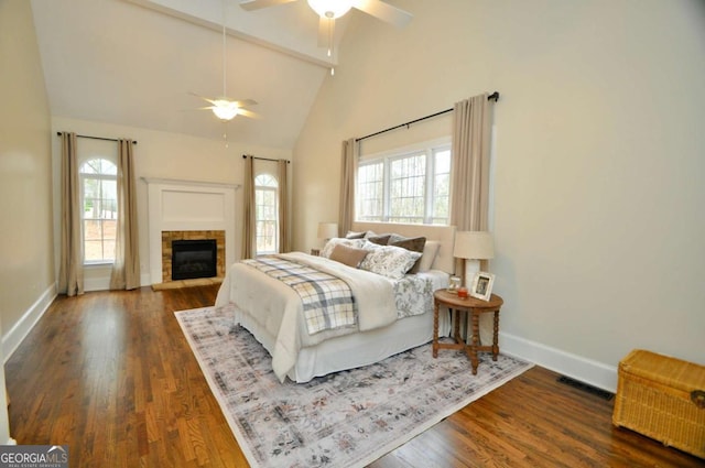 bedroom featuring visible vents, high vaulted ceiling, wood finished floors, baseboards, and ceiling fan