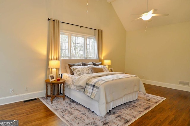 bedroom featuring visible vents, high vaulted ceiling, baseboards, and wood finished floors