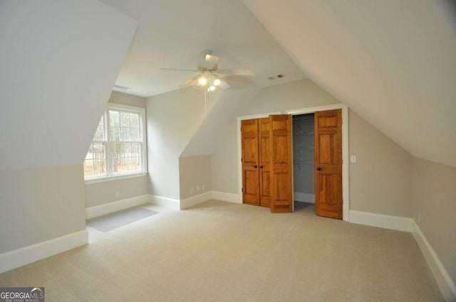 bonus room featuring a ceiling fan, baseboards, visible vents, vaulted ceiling, and light colored carpet