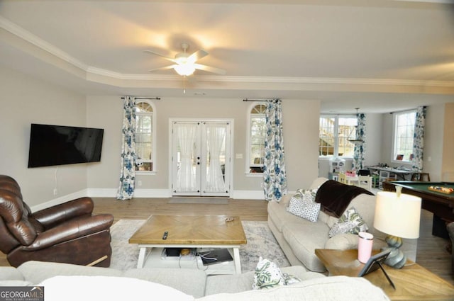 living area with french doors, baseboards, wood finished floors, and ornamental molding