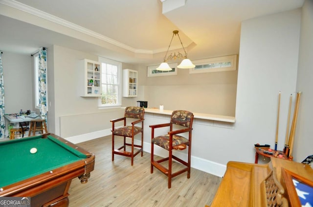 rec room with baseboards, crown molding, a tray ceiling, and wood finished floors