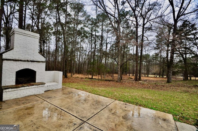 view of patio with an outdoor brick fireplace