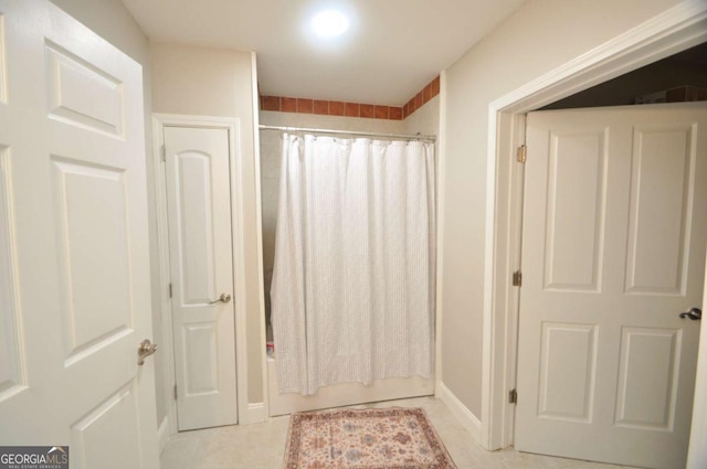 bathroom featuring tile patterned floors and shower / tub combo with curtain