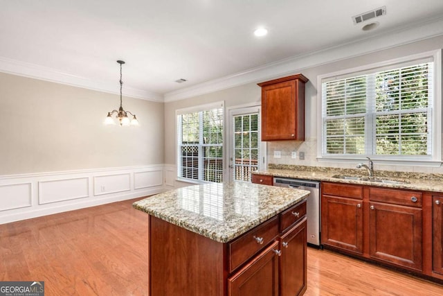 kitchen with light stone counters, visible vents, a sink, and stainless steel dishwasher