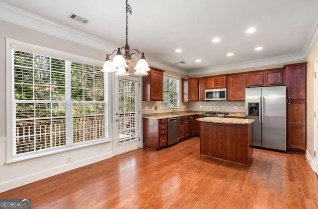 kitchen with visible vents, stainless steel appliances, crown molding, and wood finished floors