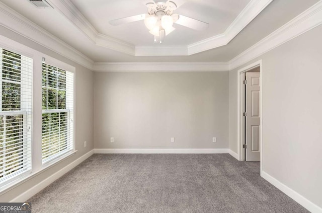 empty room with baseboards, a raised ceiling, ornamental molding, and carpet flooring