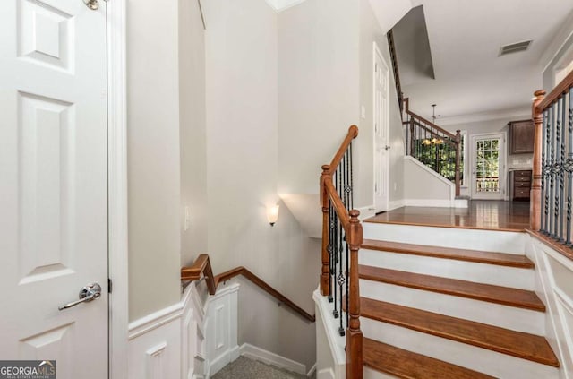 staircase with visible vents and baseboards