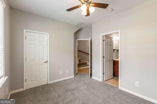 unfurnished bedroom with light carpet, visible vents, ensuite bathroom, and baseboards