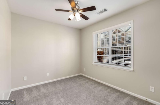 unfurnished room with visible vents, carpet flooring, a ceiling fan, and baseboards