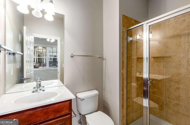 full bath with toilet, a stall shower, and vanity