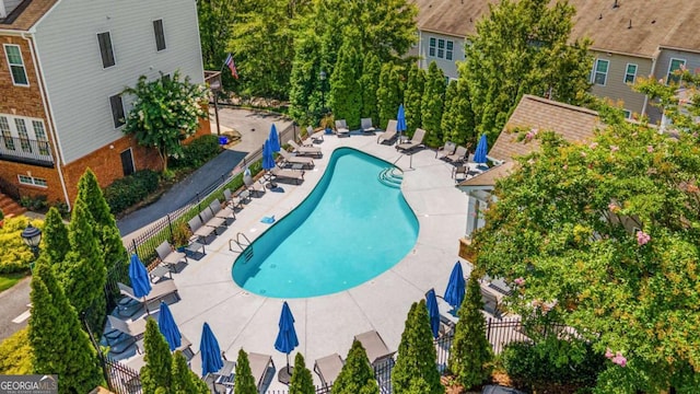 community pool featuring a patio and fence