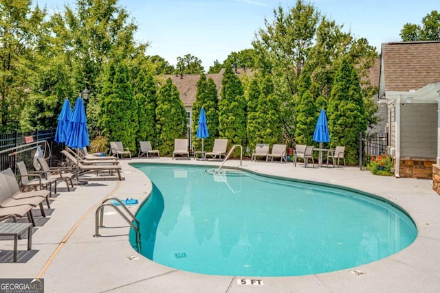 community pool featuring a patio area and fence