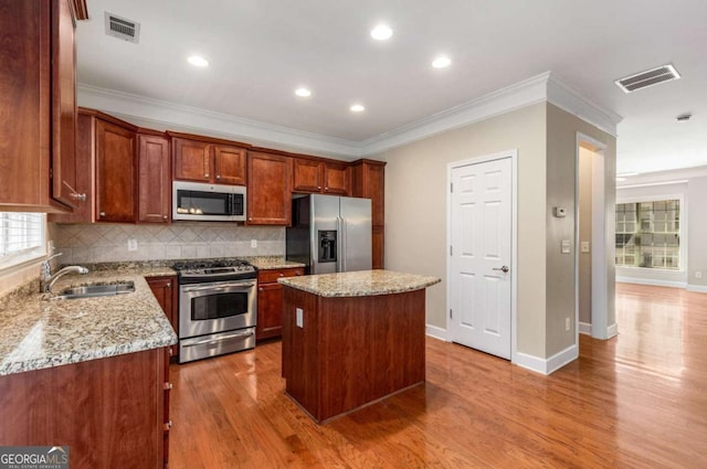 kitchen featuring light wood finished floors, visible vents, stainless steel appliances, and a sink